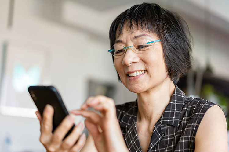Asian woman on iPhone using Patient Hub
